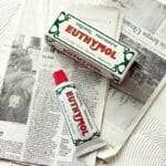 Euthymol Original Zahnpasta – Fluoridfreie Mundpflege mit einzigartigem Geschmack und rosa Farbe. Produkt Abbildung Zahnpasta auf Zeitung