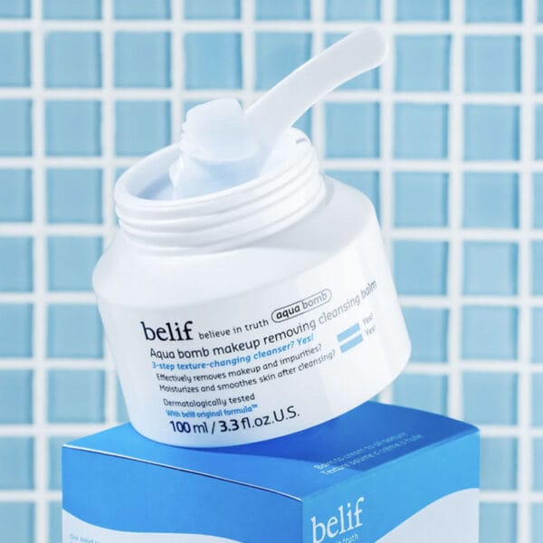 belif Cleansing Balm 100ml - Moisturizing make-up removing balm with lotus flower & vitamin E. Image picture with applicator, without lid, bathroom tiles in the background.