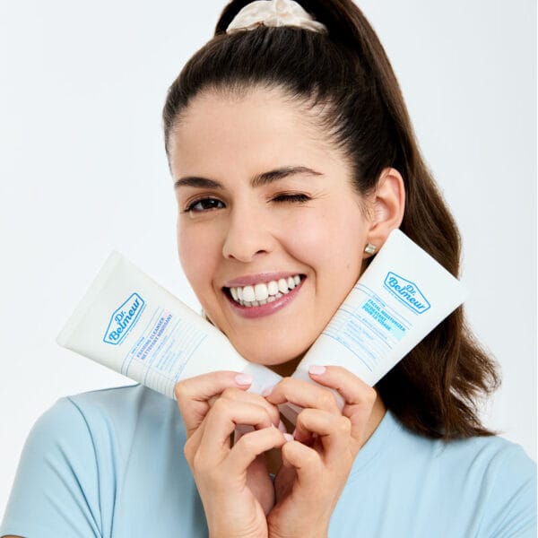 Dr. Belmeur Balancing Water Cream – leichte Feuchtigkeitscreme für fettige & empfindliche Haut, reguliert Talg und spendet Feuchtigkeit. Abbildung Frau hält zwei Produkte.