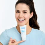 Dr. Belmeur Balancing Water Cream – leichte Feuchtigkeitscreme für fettige & empfindliche Haut, reguliert Talg und spendet Feuchtigkeit. Abbildung Frau hält Produkt unter dem Kinn.