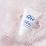 Dr. Belmeur Daily Repair Foaming Cleanser 150ml - mousse nettoyante douce au pH équilibré, à l'extrait de bouleau et au panthénol, pour les peaux sensibles. Illustration Cleanser dans un bain moussant. 