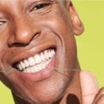 18230992 REACH POP Dental Floss Peppermint Floss - vegan, waxed dental floss with 384 micro threads & sustainable packaging, 50m, peppermint flavor. Picture dental floss in action. 